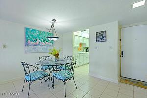 4175 S Atlantic Ave Unit 405, New Smyrna Beach, FL 32169 - dining space featuring baseboards and light tile patterned flooring
