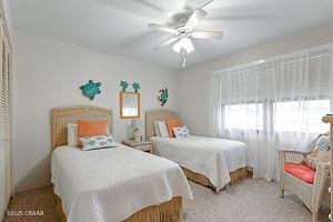 4175 S Atlantic Ave Unit 405, New Smyrna Beach, FL 32169 - bedroom featuring a ceiling fan and carpet