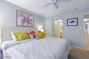 4175 S Atlantic Ave Unit 405, New Smyrna Beach, FL 32169 - bedroom with baseboards, ceiling fan, and carpet flooring