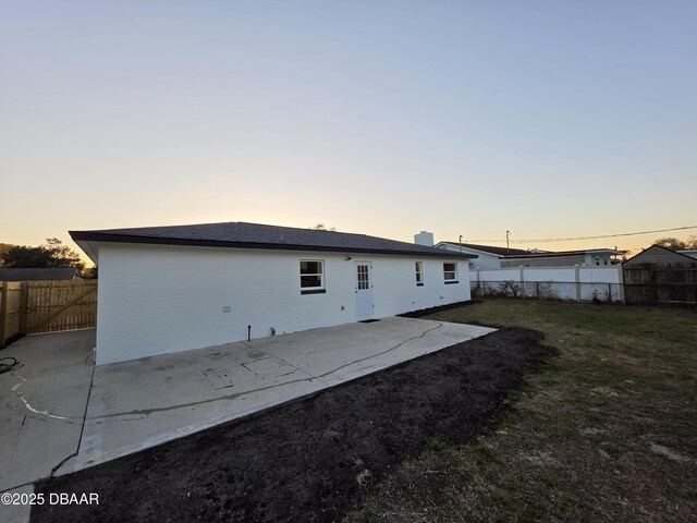 1909 Nelson Ave, Ormond Beach, FL 32174 - back of property with a patio area, a fenced backyard, a lawn, and a chimney