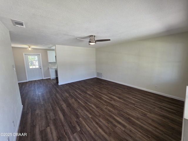 unfurnished living room with visible vents, baseboards, ceiling fan, and dark wood-style flooring