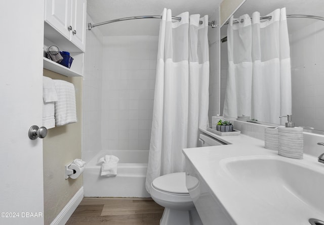 full bathroom featuring hardwood / wood-style flooring, toilet, shower / bathtub combination with curtain, and sink