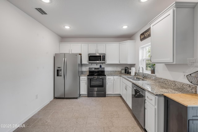 kitchen with a sink, white cabinets, appliances with stainless steel finishes, visible vents, and recessed lighting