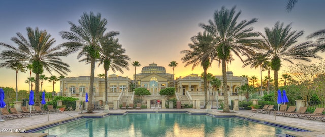 pool at dusk featuring a patio