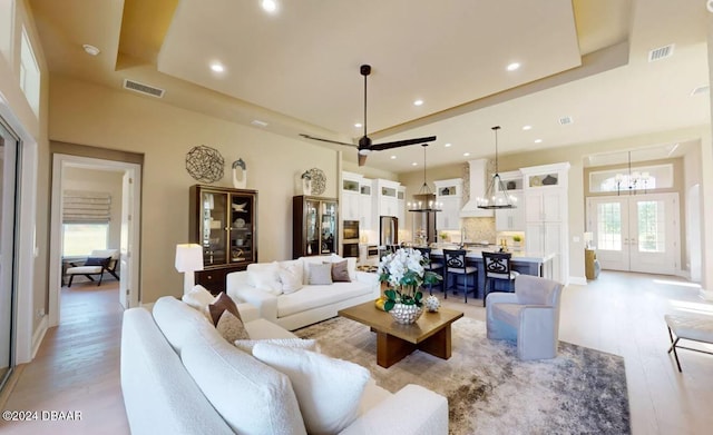 living room featuring an inviting chandelier, a high ceiling, and light wood-type flooring