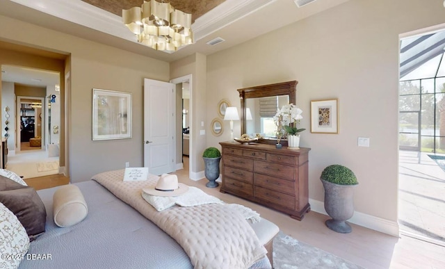 bedroom featuring a chandelier, access to outside, and a tray ceiling