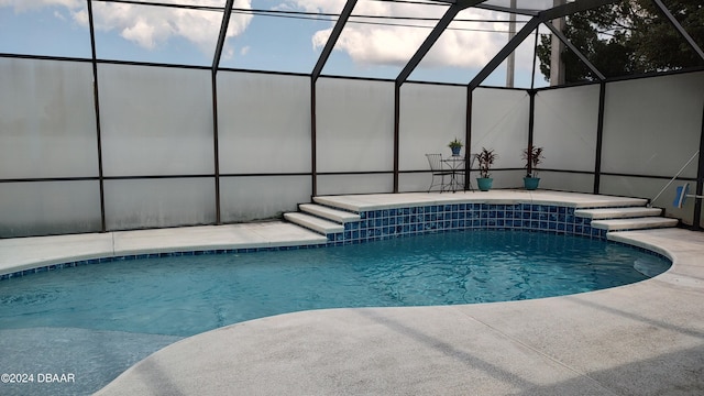 view of swimming pool featuring glass enclosure and a patio area