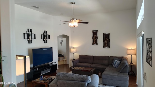 living room featuring a high ceiling, ceiling fan, and dark hardwood / wood-style flooring