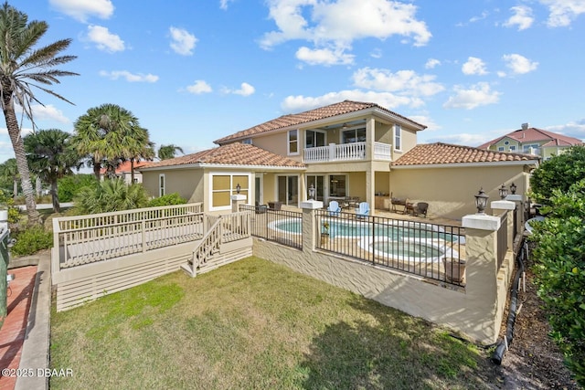 back of property with ceiling fan, a yard, a patio, and a balcony