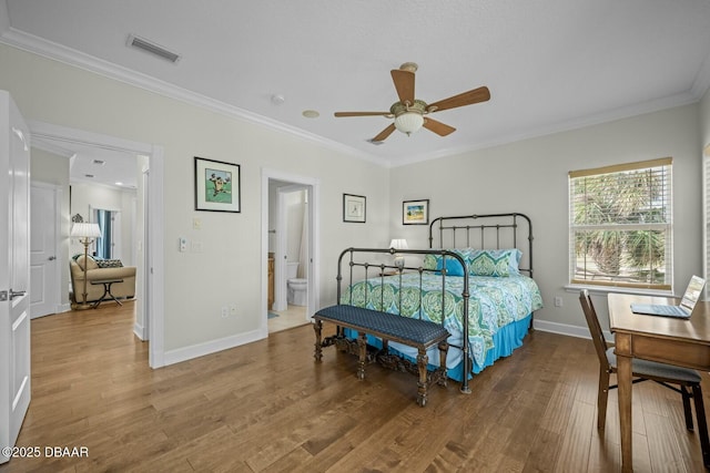 bedroom with crown molding, ceiling fan, wood-type flooring, and ensuite bath