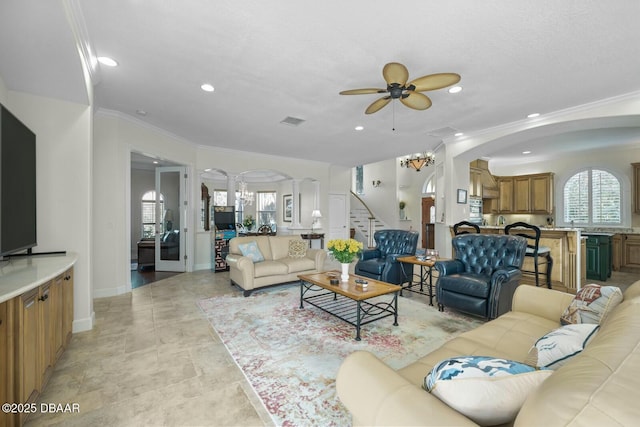 living room with ornamental molding, decorative columns, and ceiling fan