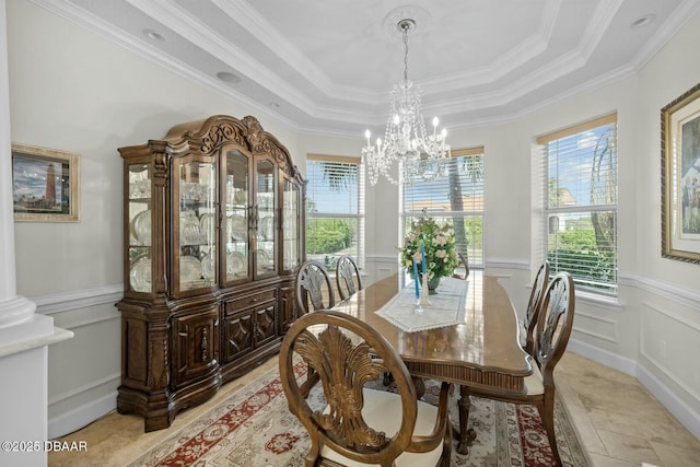 dining area featuring a raised ceiling, crown molding, and an inviting chandelier