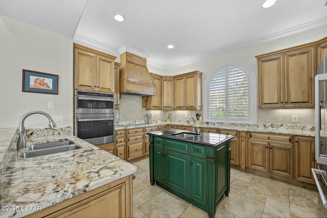 kitchen with premium range hood, an island with sink, double oven, and sink