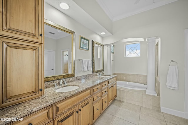 bathroom with decorative columns, vanity, a relaxing tiled tub, ornamental molding, and tile patterned floors