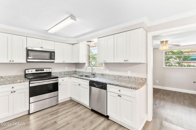 kitchen with stainless steel appliances, white cabinetry, a wealth of natural light, and sink