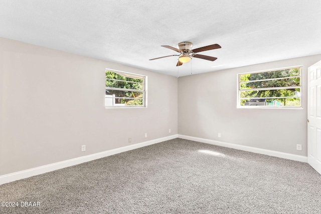 carpeted spare room featuring ceiling fan, plenty of natural light, and a textured ceiling