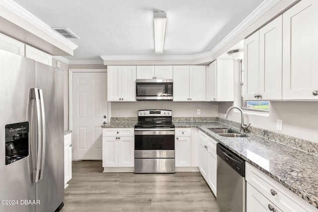 kitchen with white cabinets, sink, stainless steel appliances, and light hardwood / wood-style flooring