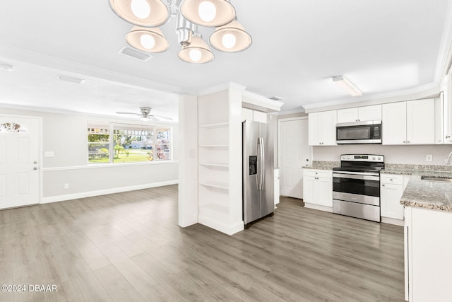 kitchen with white cabinetry, ceiling fan, stainless steel appliances, wood-type flooring, and ornamental molding