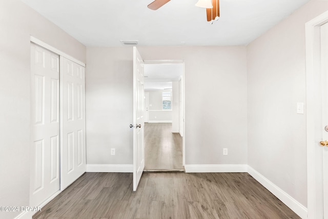 unfurnished bedroom with hardwood / wood-style floors, a closet, and ceiling fan