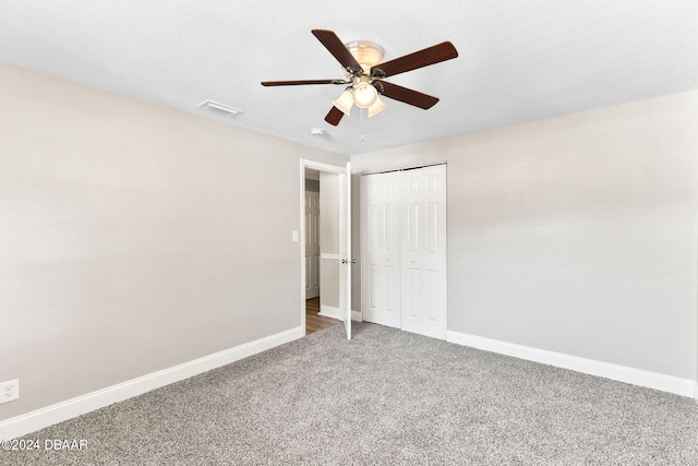 unfurnished bedroom featuring carpet flooring, ceiling fan, a textured ceiling, and a closet