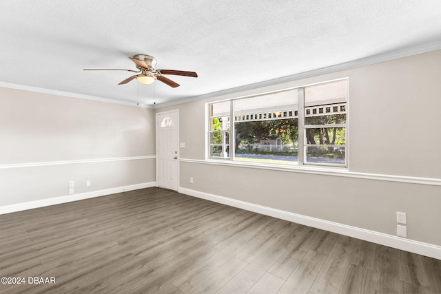 empty room with dark hardwood / wood-style floors, ceiling fan, ornamental molding, and a textured ceiling