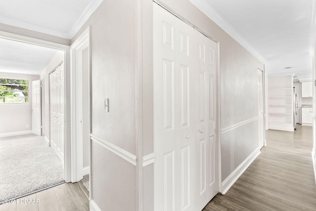 corridor with hardwood / wood-style floors and ornamental molding