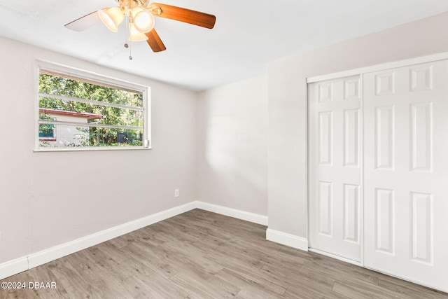 unfurnished bedroom with ceiling fan, light wood-type flooring, and a closet