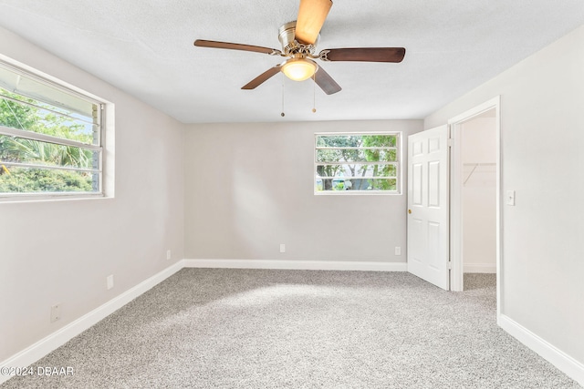 spare room with carpet, a textured ceiling, and ceiling fan