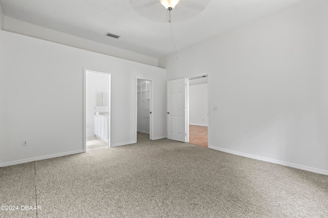 3864 Long Grove Ln, Port Orange, FL 32129 - unfurnished bedroom with a closet, a walk in closet, connected bathroom, carpet flooring, and ceiling fan