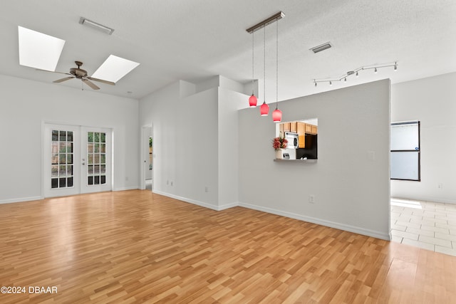 3864 Long Grove Ln, Port Orange, FL 32129 - unfurnished living room featuring light hardwood / wood-style floors, ceiling fan, a textured ceiling, a skylight, and french doors