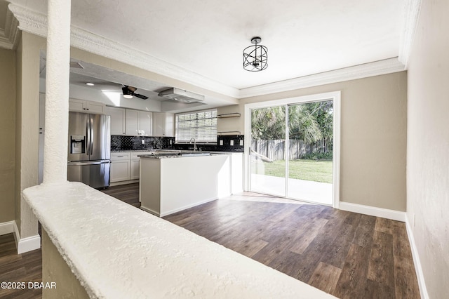 kitchen with pendant lighting, sink, stainless steel refrigerator with ice dispenser, ceiling fan, and white cabinetry