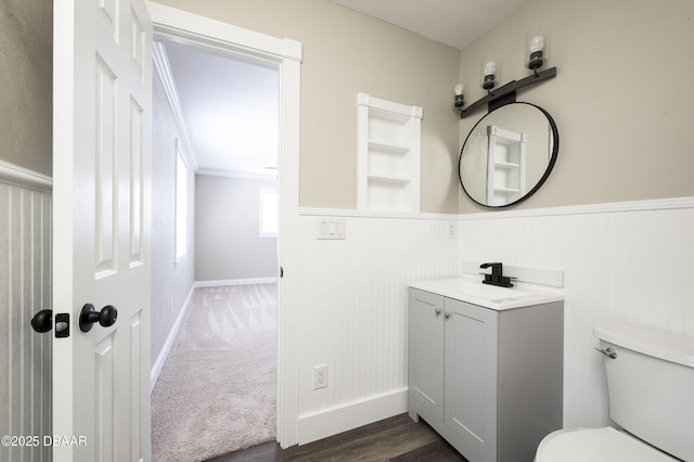 bathroom with crown molding, built in features, vanity, and toilet