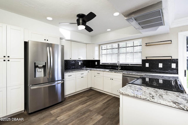 kitchen with white cabinets, appliances with stainless steel finishes, light stone counters, and ceiling fan