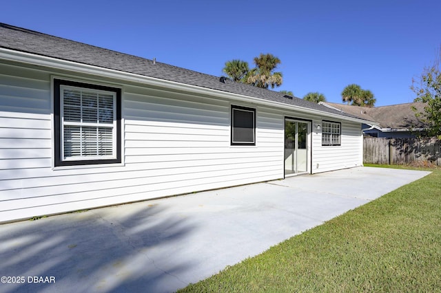 back of house with a lawn and a patio