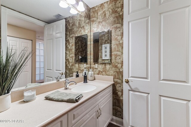 4672 Riverwalk Village Ct Unit 8203, Ponce Inlet, FL 32127 - bathroom with wallpapered walls, visible vents, and vanity