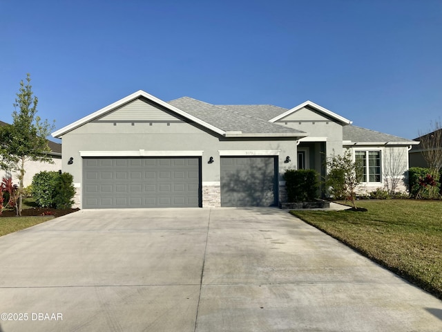 ranch-style house with a garage, concrete driveway, roof with shingles, a front yard, and stucco siding