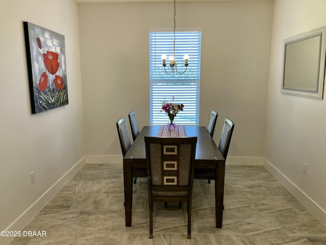 dining area featuring baseboards and a chandelier