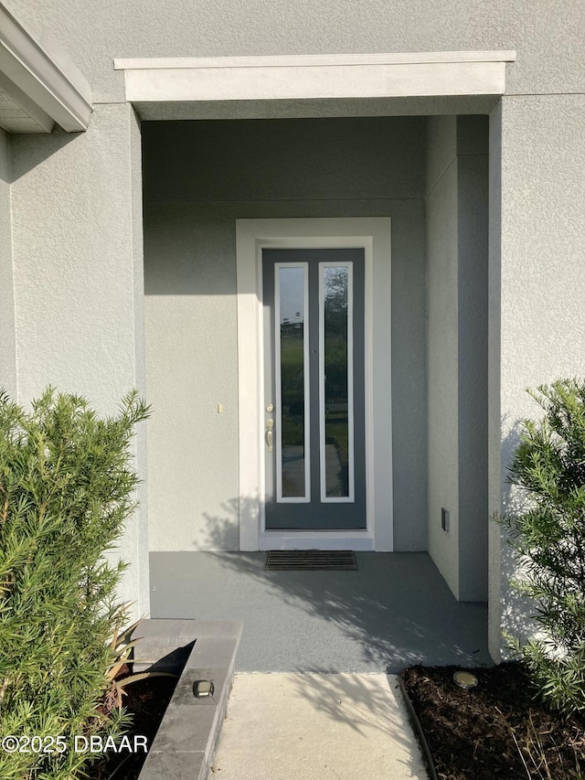 doorway to property with stucco siding