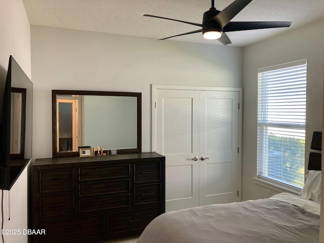 bedroom with a closet, ceiling fan, and a textured ceiling