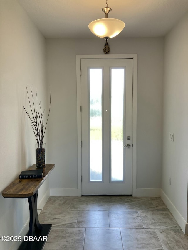 doorway featuring baseboards