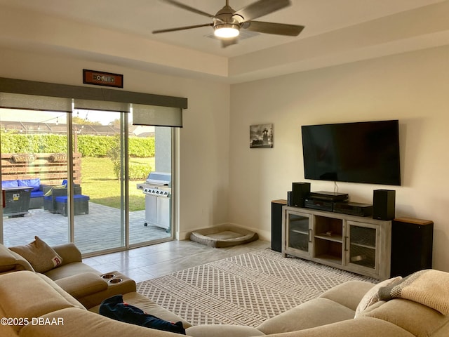 living room featuring tile patterned flooring, baseboards, and a ceiling fan