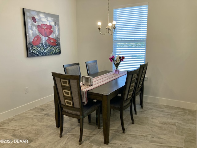 dining area with a chandelier and baseboards