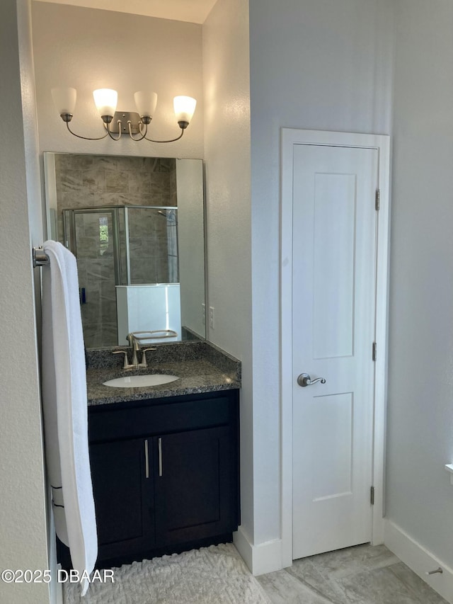 full bathroom with a shower stall, vanity, and baseboards