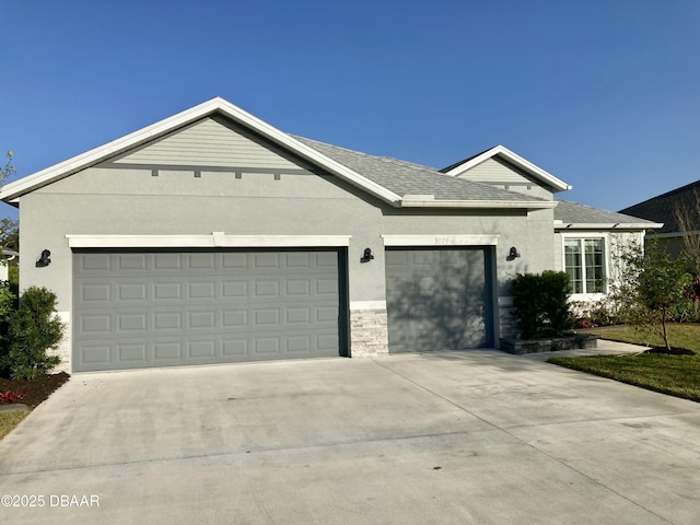 single story home featuring a garage, concrete driveway, stone siding, and stucco siding