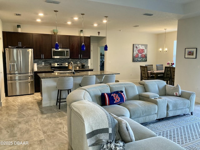 living area featuring visible vents, a chandelier, and recessed lighting