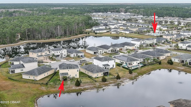 birds eye view of property featuring a forest view, a residential view, and a water view