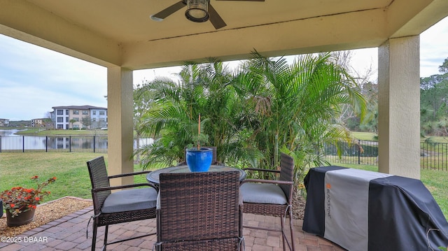 view of patio with a fenced backyard, area for grilling, ceiling fan, and a water view