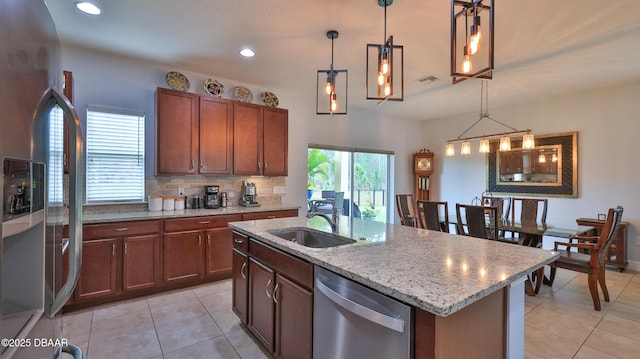 kitchen with visible vents, a sink, stainless steel appliances, decorative light fixtures, and backsplash