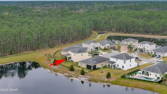 drone / aerial view featuring a residential view, a view of trees, and a water view