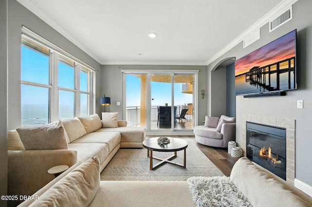 2515 S Atlantic Ave Unit 502, Daytona Beach, FL 32118 - living area featuring ornamental molding, a tiled fireplace, wood finished floors, arched walkways, and baseboards